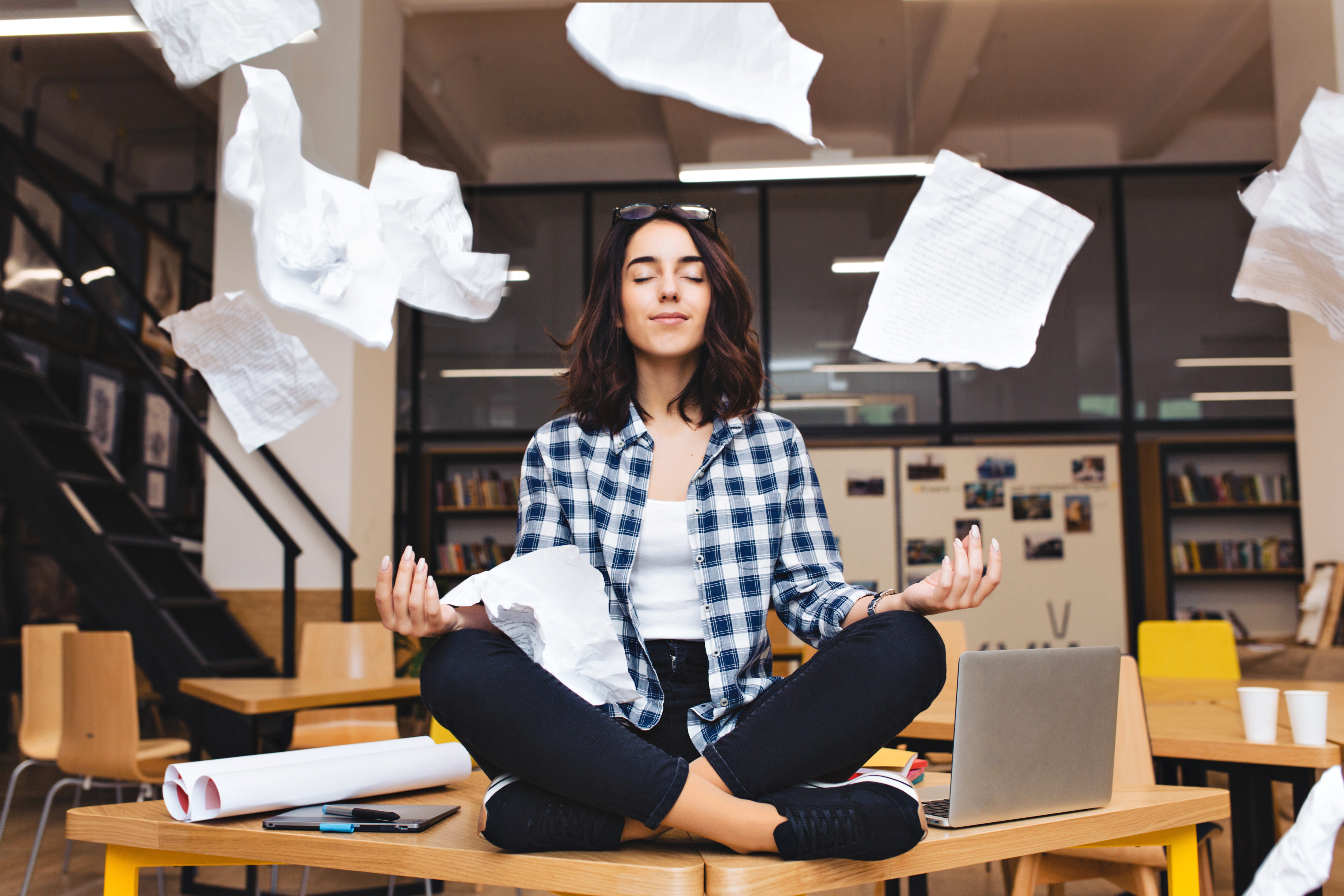 young pretty joyful brunette woman meditating table surround work stuff flying papers cheerful mood taking break working studying relaxation true emotions